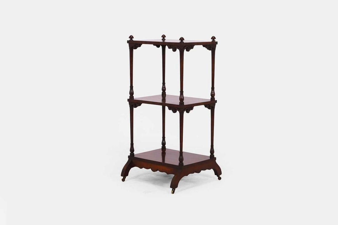 A George IV mahogany étagère, c.1830,: A George IV mahogany étagère, c.1830, the rectangular top set with turned finials, above two further shelves, set between fluted columns with foliate detail, raised on splayed feet terminati