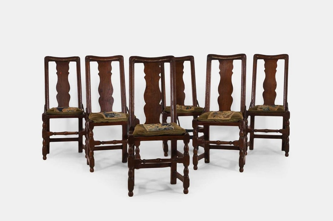 A set of six provincial oak dining chairs, first half of the 18th century,: A set of six provincial oak dining chairs, first half of the 18th century, each with a moulded rail and a vase-shaped splat, above a square seat fitted with twisted iron braces, raised on turned and b