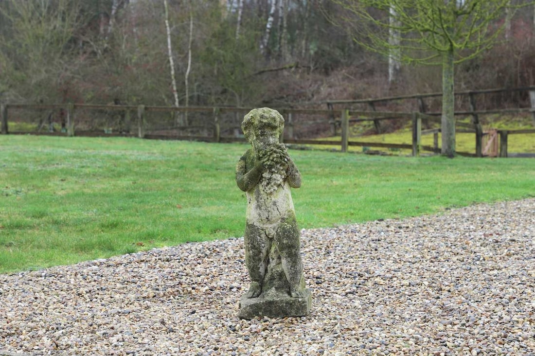 A reconstituted stone putto, 20th century, (1 of 3)