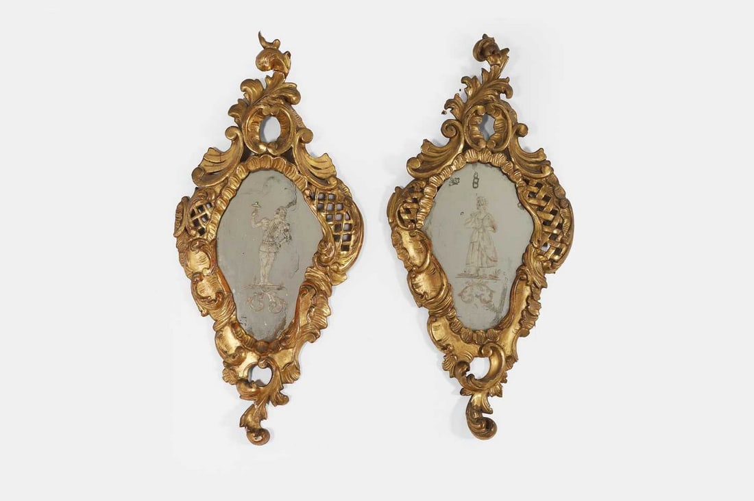 A pair of Venetian giltwood girandoles, c.1750, Italian,: A pair of Venetian giltwood girandoles, c.1750, Italian, the etched mirror plates depicting a gentleman and lady, probably lovers, each within a pierced and carved giltwood scroll frame (28.5cm wide,