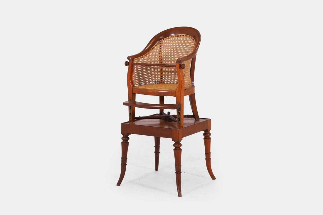 A mahogany child's high chair, c.1870,: A mahogany child's high chair, c.1870, with a cane seat and back, attached to a square stand with ring-turned supports (39cm wide, 43cm deep, 97cm high) Condition Report: General light knocks and wear
