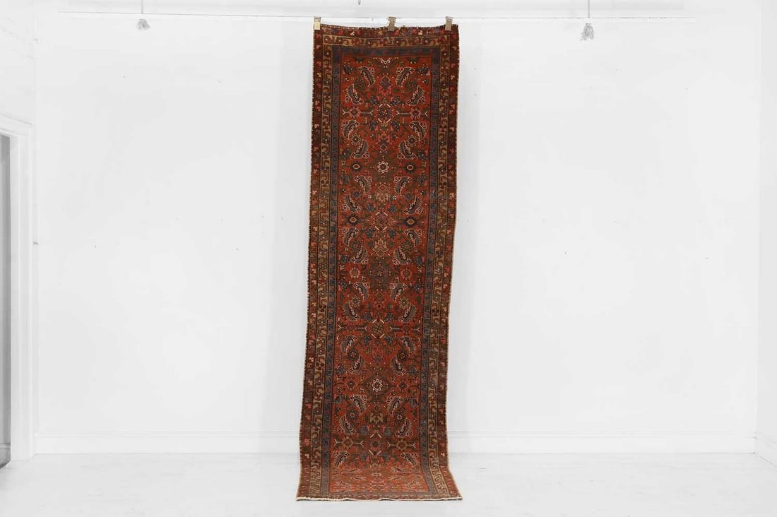A Heriz wool runner, 20th century,: A Heriz wool runner, 20th century, the red field with all-over polychrome, palmette and geometric detail (326 x 81cm) Provenance: Donnington Castle House, Newbury, Berkshire. Condition Report: Good co