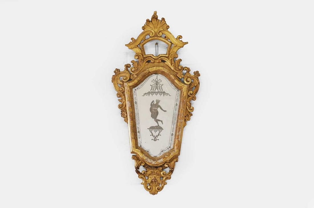 A Venetian giltwood girandole, 18th century, Italian,: A Venetian giltwood girandole, 18th century, Italian, the etched mirror plate depicting classical motifs, enclosed within a carved giltwood scroll frame (45cm wide, 95cm high) Condition Report: Genera
