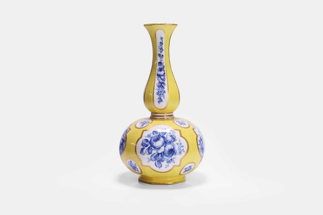A faience double-gourd vase, 19th century, French,: A faience double-gourd vase, 19th century, French, tin-glazed earthenware, painted with gilt reserves on a yellow ground, alternating between scenes of cherubs and peony bouquets in blue and white (16