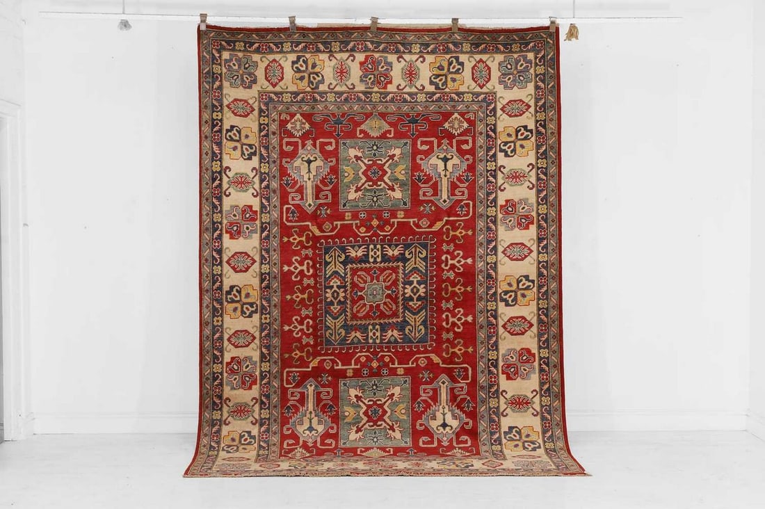 An Oushak wool carpet of Karachov Kazak design, of recent manufacture,: An Oushak wool carpet of Karachov Kazak design, of recent manufacture, the ivory and red field with all-over polychrome, geometric and floral detail (295 x 199cm)