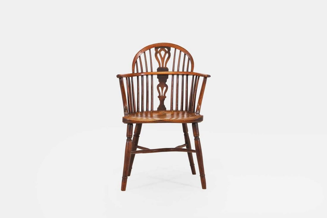 A yew and elm Windsor armchair, early 19th century, North-East Midlands,: A yew and elm Windsor armchair, early 19th century, North-East Midlands, with a low hoop back with a pierced splat, raised on single ring-turned supports united by a crinoline stretcher (58.5cm wide,