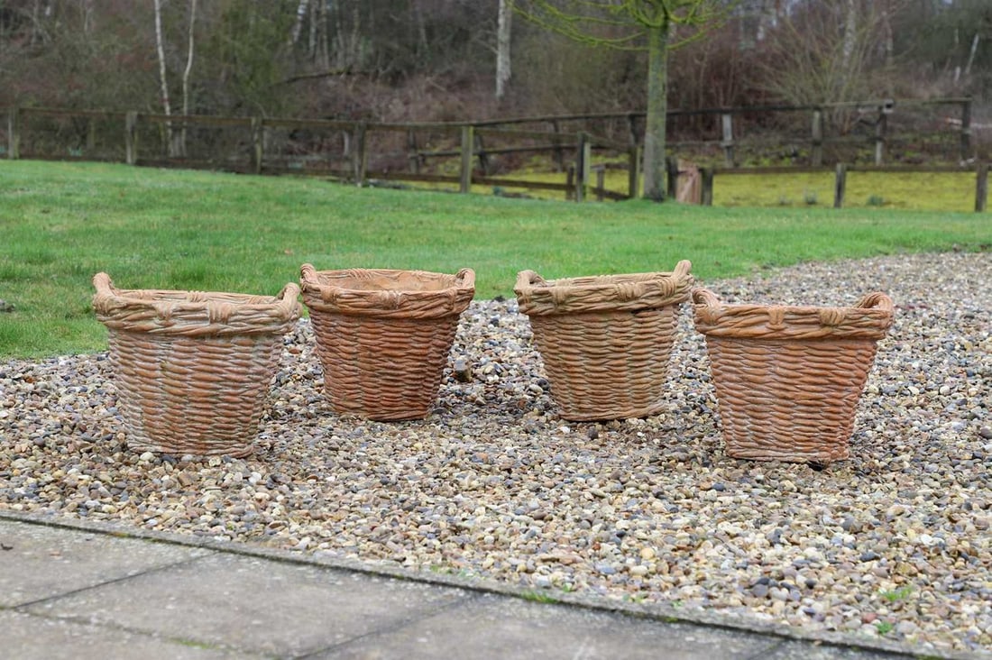 A set of four terracotta garden pots, of recent manufacture, French,: A set of four terracotta garden pots, of recent manufacture, French, each in the form of a basket, with loop handles (42cm diameter, 37cm high) (4)