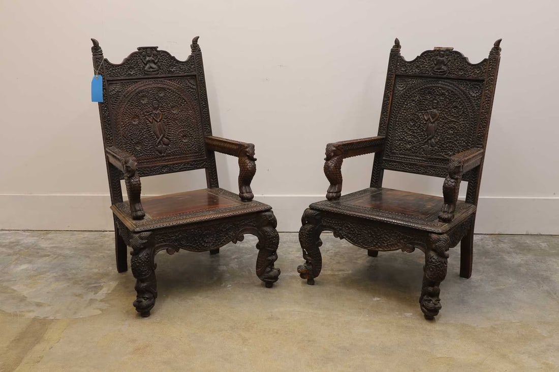 A pair of carved hardwood armchairs, 20th century, Anglo-Indian,: A pair of carved hardwood armchairs, 20th century, Anglo-Indian, each profusely carved with crolling foliage, figures and animals 68cm wide, 68cm deep,109cm high, seat 38cm 2 Condition Report: