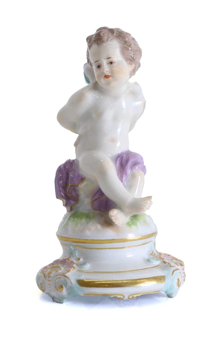A Meissen figure of a seated cherub, circa 1900,: A Meissen figure of a seated cherub, circa 1900, with bound hands, with blue cross swords to the base, and numbered '3' in red to the base 6.2cm wide, 10cm high