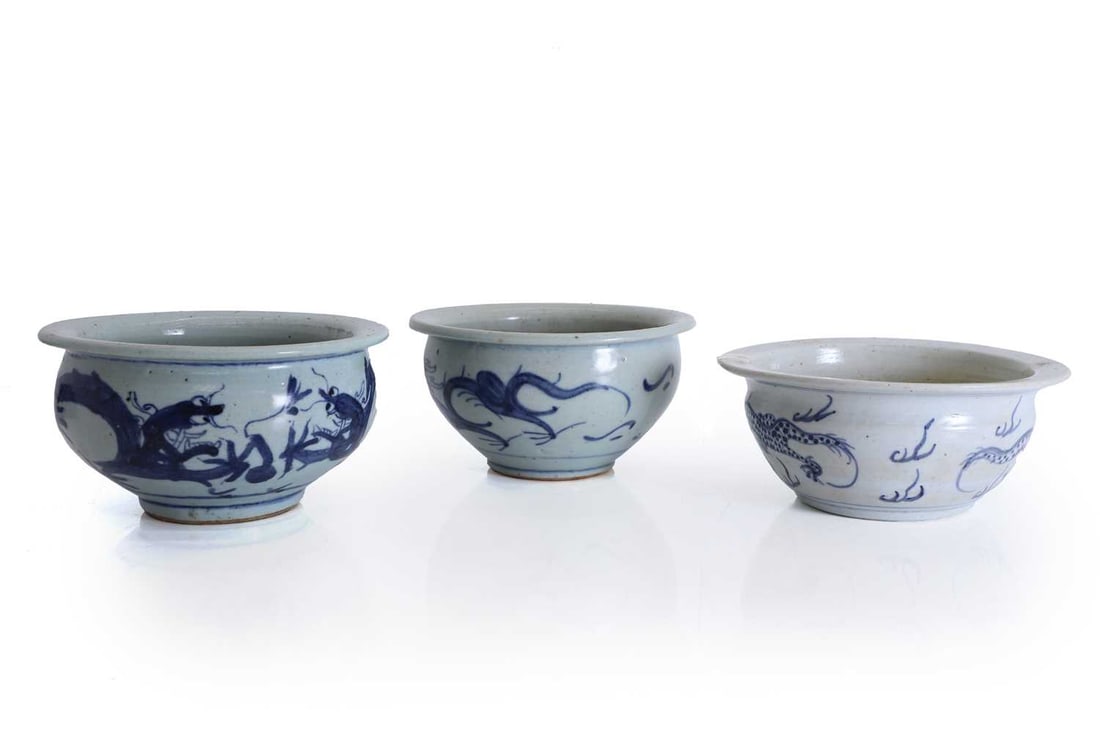 A pair of Chinese blue and white bowls, 18th century,: A pair of Chinese blue and white bowls, 18th century, possibly Nankin Cargo, both decorated with scrolling dragons, together with another example, decorated with two four clawed dragons facing a