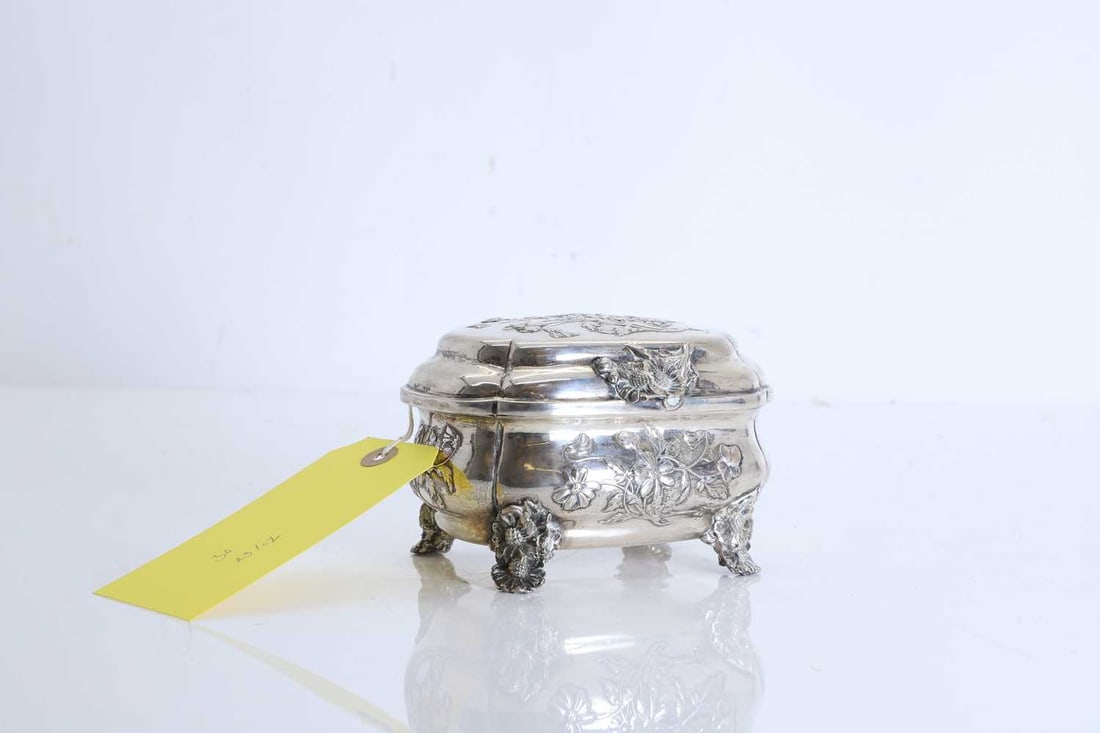 An Austrian silver and silver gilt hinged casket, late 19th to early 20th century,: An Austrian silver and silver gilt hinged casket, late 19th to early 20th century, of oval form with shaped corners, the hinged cover chased with flowering sprays and with a floral thumbpiece, the