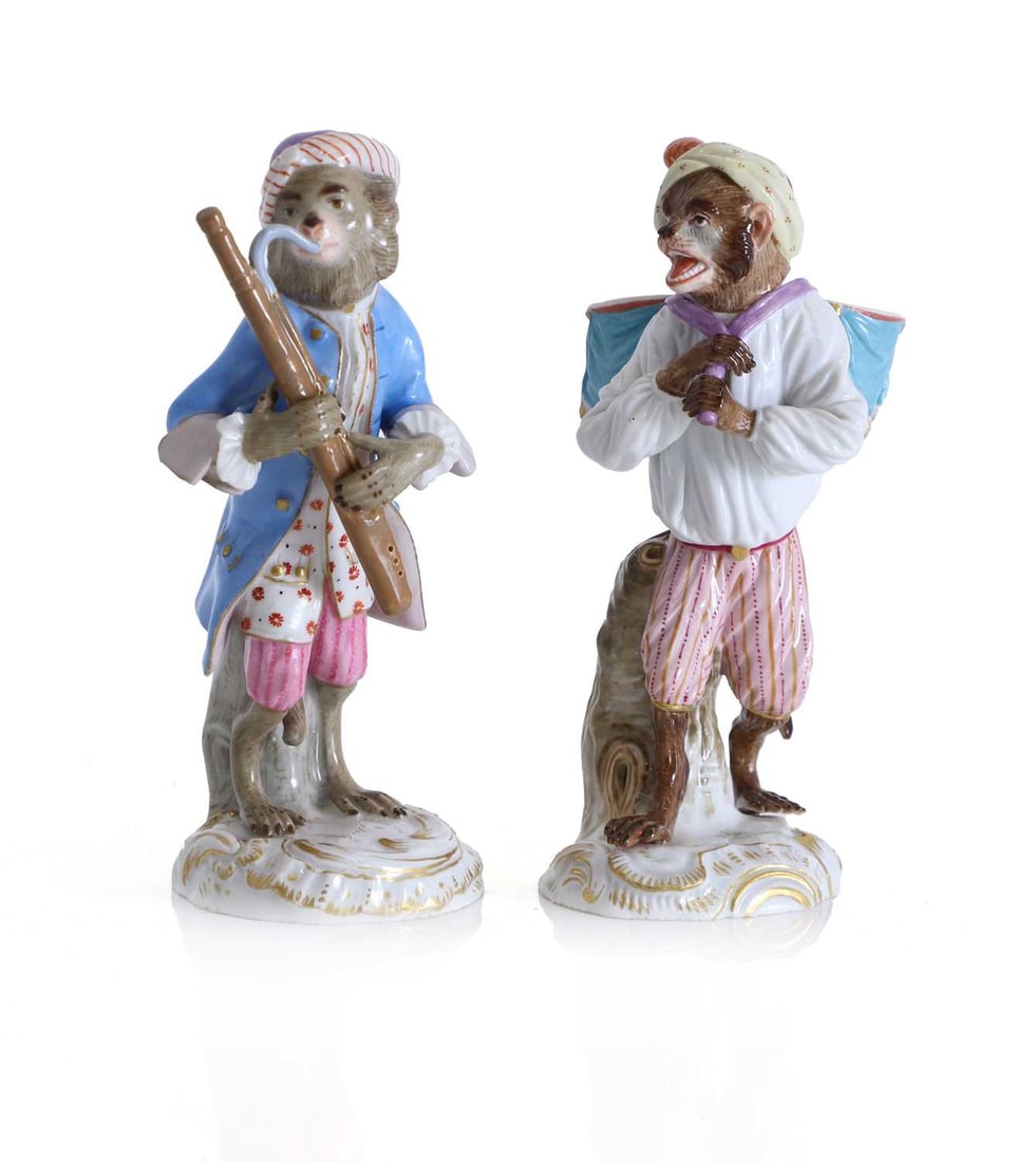 Two Meissen figures of monkey musicians, late 19th century,: Two Meissen figures of monkey musicians, late 19th century, comprising a figure modelled as an anthropomorphic monkey standing standing before a tree stump, dressed in 18th century costume of a pale