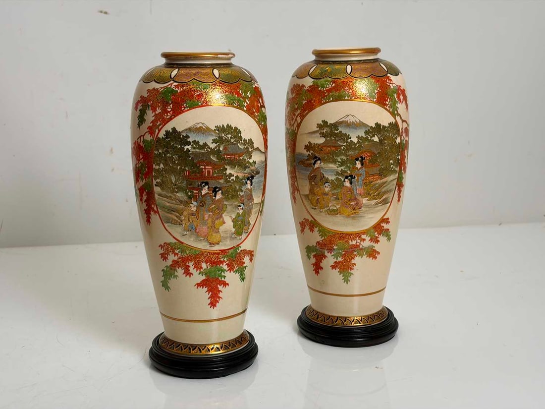 A pair of Japanese satsuma vases, early 20th century,: A pair of Japanese satsuma vases, early 20th century, each decorated in enamels and gilt, painted with a oval panel of seated female figures and boys in a mountainous landscape, surrounded by