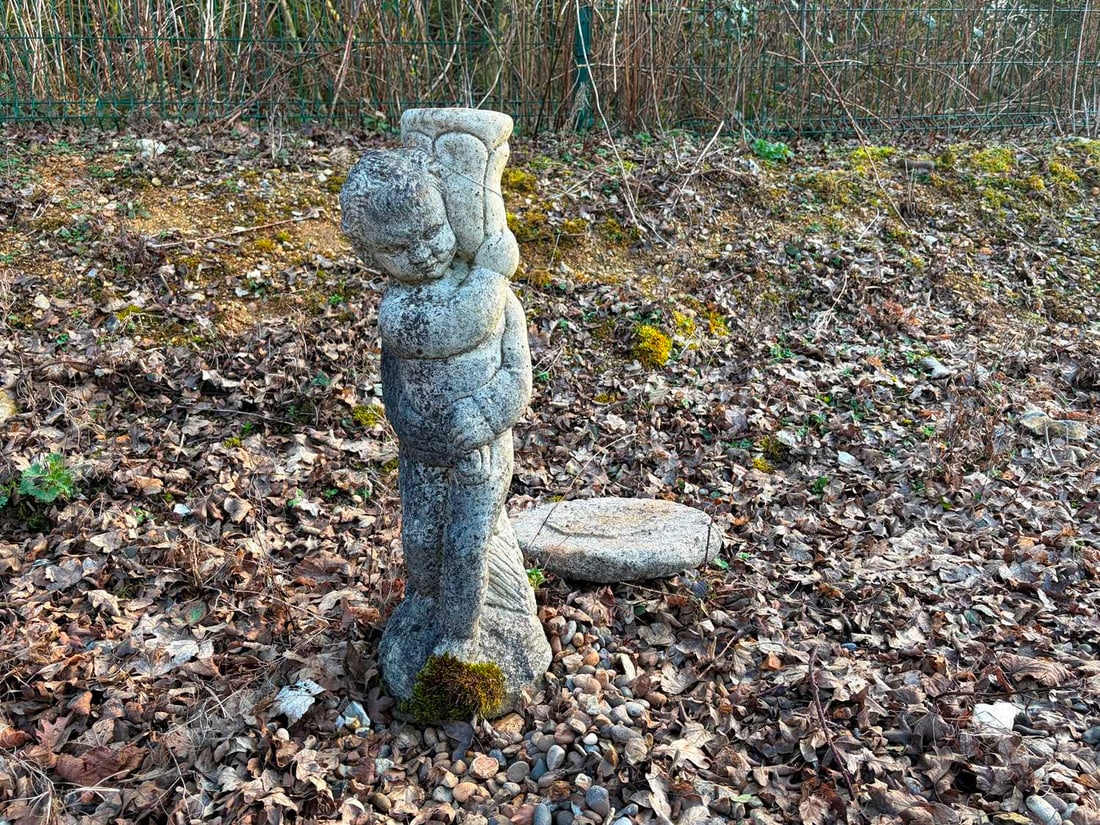 A stone figure ornament, 20th century,: A stone figure ornament, 20th century, depicting a cherub holding an urn, together with a sun dial, composite, with Roman numeral face Largest, 80cm high 2