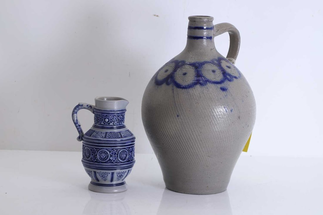 Large stoneware glazed flagon, circa 1880, French,: Large stoneware glazed flagon, circa 1880, French, with grey ground and blue circular design, together with a German Westerwald salt glazed stoneware jug, decorated with traditional design, stamped