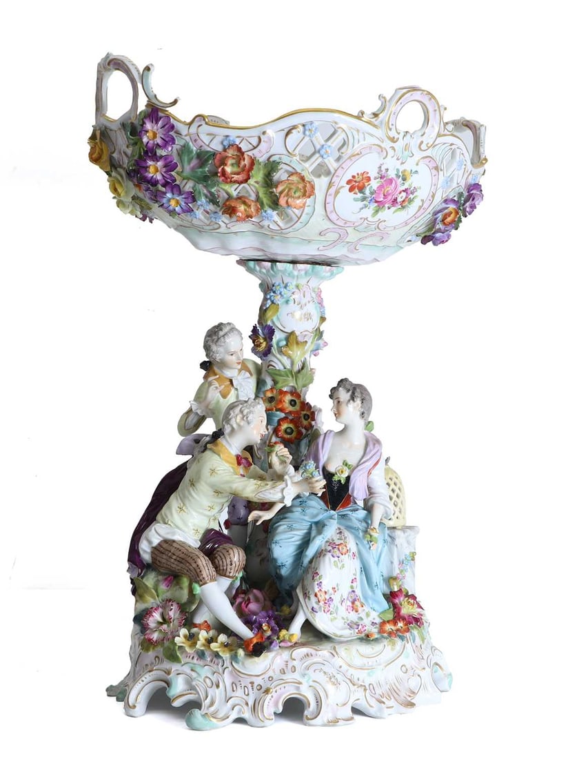 A Potschappel table centre, 19th century,: A Potschappel table centre, 19th century, the four handled pierced and floral encrusted bowl above the floral encrusted pedestal flanked by a seated lady attended by her admirers, raised on a