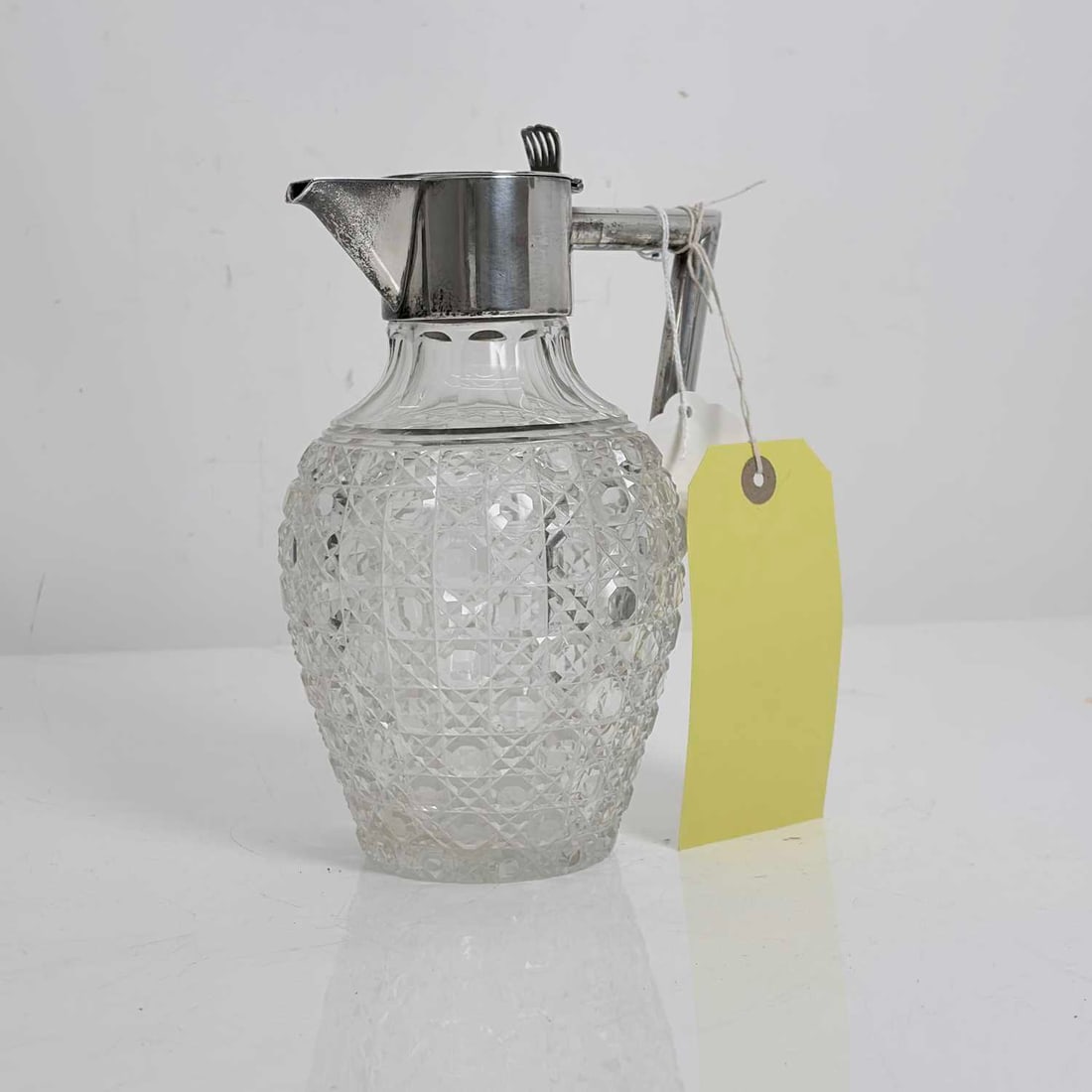 A silver mounted and cut glass claret jug, late 19th century,: A silver mounted and cut glass claret jug, late 19th century, by Charles Boyton (II), London 1897, the tapering body cut with a geometric hobnail pattern of octagonal panels and diamond facets, the