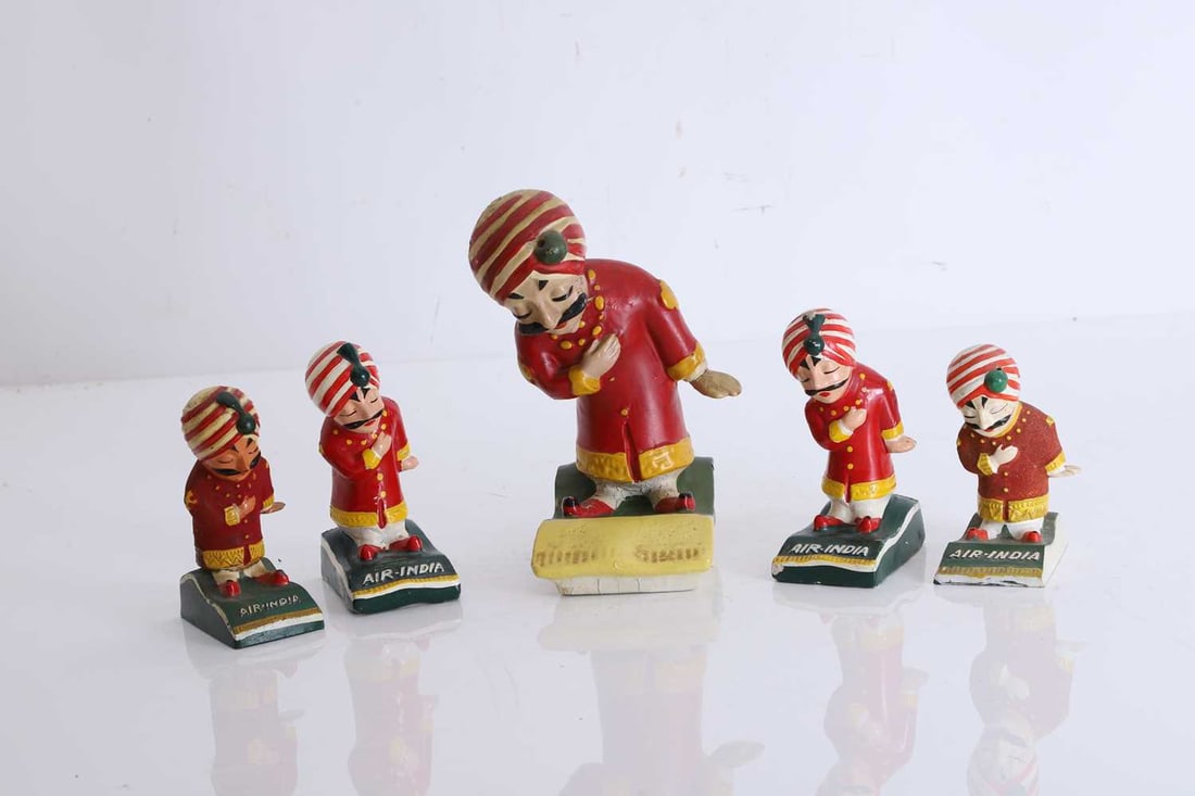 Five Air India Maharaja figures, circa 1960s,: Five Air India Maharaja figures, circa 1960s, made from various materials, all figures in typical Air-India dress, and some with labels to the bases The largest, 17cm high 5 Condition Report: All