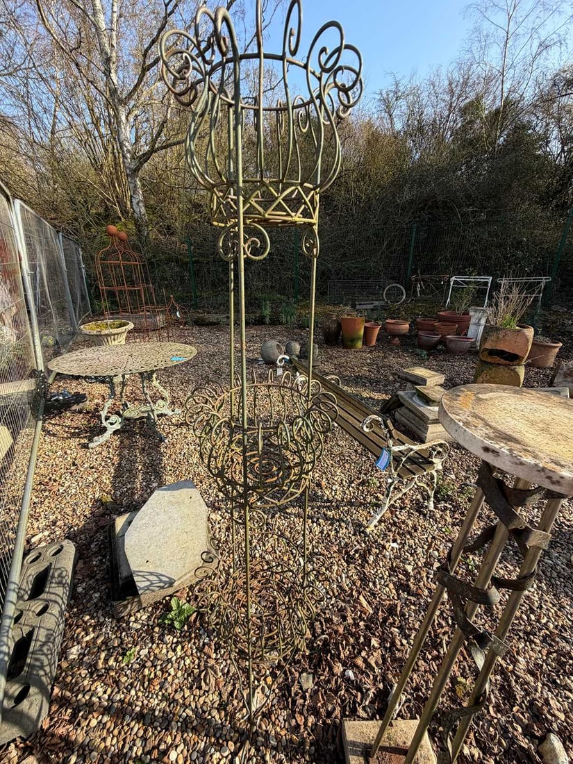 A wrought iron plant stand, 20th century,: A wrought iron plant stand, 20th century, three tiers and outscrolling sections, together with another contemporary example, with wrapping metal ribbon, stone base and top The largest, 182cm high