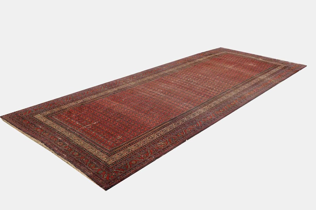 A Bokhara rug, early 20th century,: A Bokhara rug, early 20th century, the field densely decorated with a repeating boteh pattern, in red, indigo and ivory, within multiple borders of stylised floral and geometric motifs 520 x 202cmCon