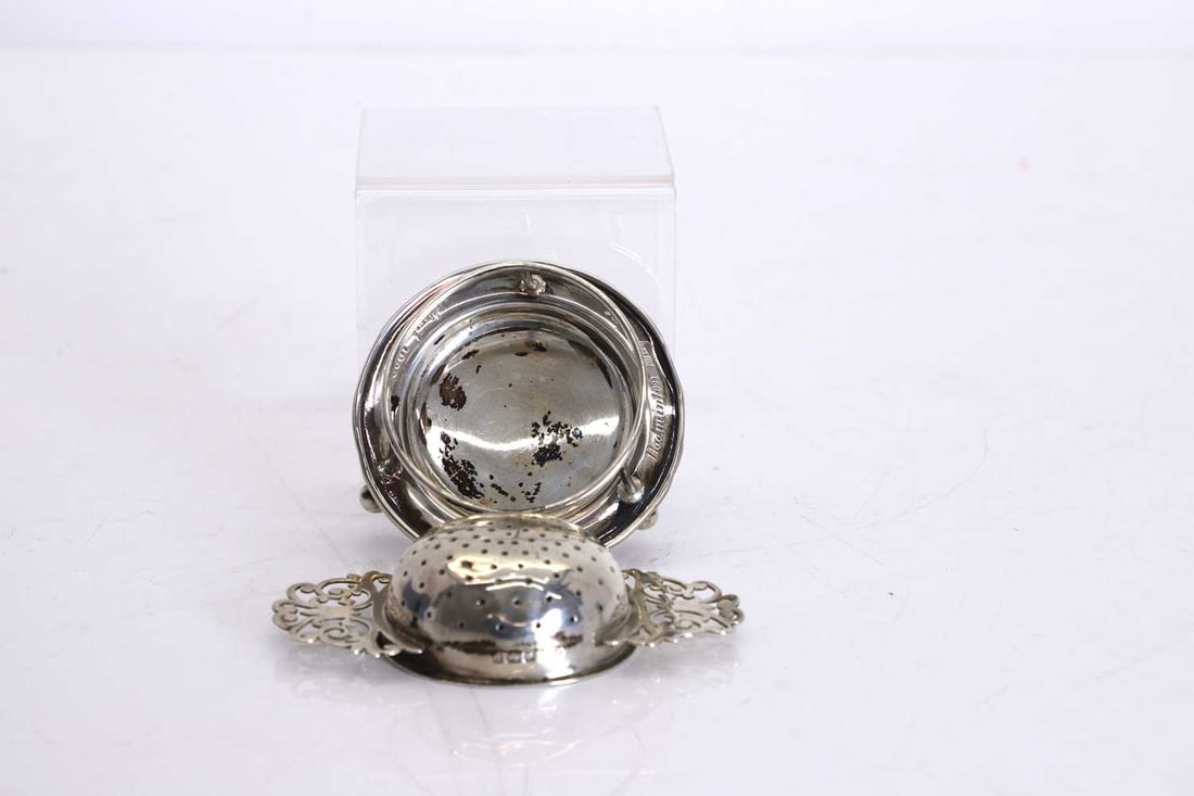 A silver tea strainer and stand, - 2