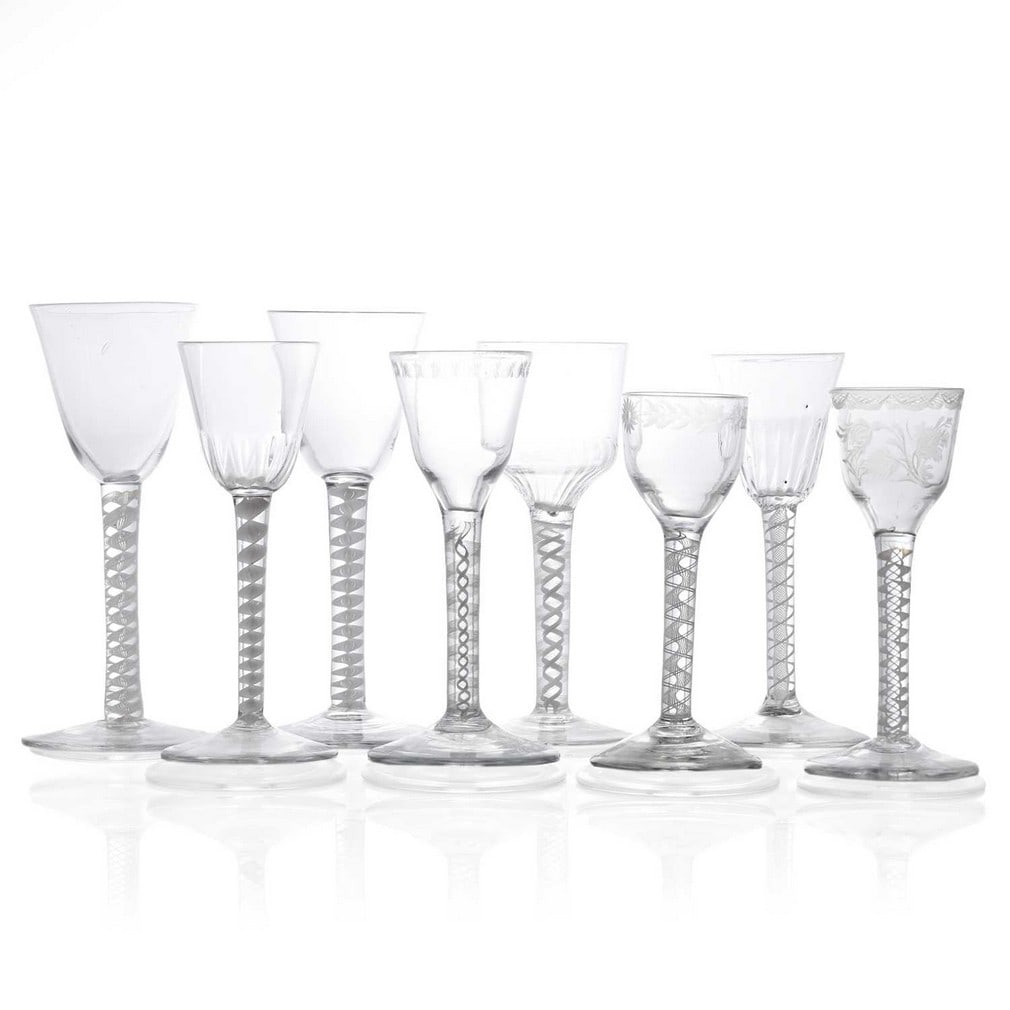 A collection of eight opaque twist wine glasses, circa 1765,: A collection of eight opaque twist wine glasses, circa 1765, comprising funnel bowl, moulded funnel bowl, engraved ogee, and moulded ogee bowl examples, each raised on an opaque twist stem and conical