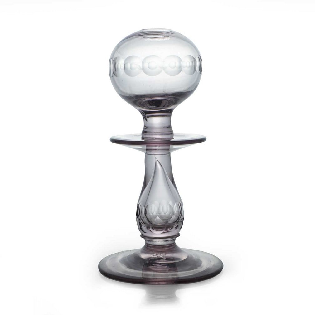 A glass lacemaker's lamp, 19th century, possibly French,: A glass lacemaker's lamp, 19th century, possibly French, the pale amethyst body with facet-cut decoration (10.5cm diameter, 19.5cm high)