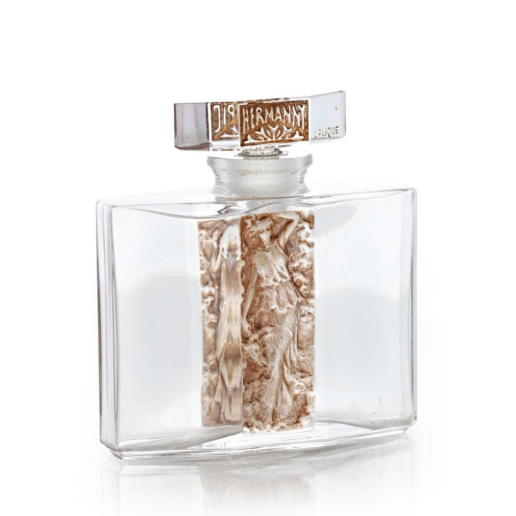 René Lalique (French, 1860-1945) for Hermanny, an 'Olimpic' scent bottle,: René Lalique (French, 1860-1945) for Hermanny, an 'Olimpic' scent bottle, of moulded and sepia-stained glass, moulded signature 'LALIQUE' (7.4cm wide, 2.4cm deep, 8cm high)