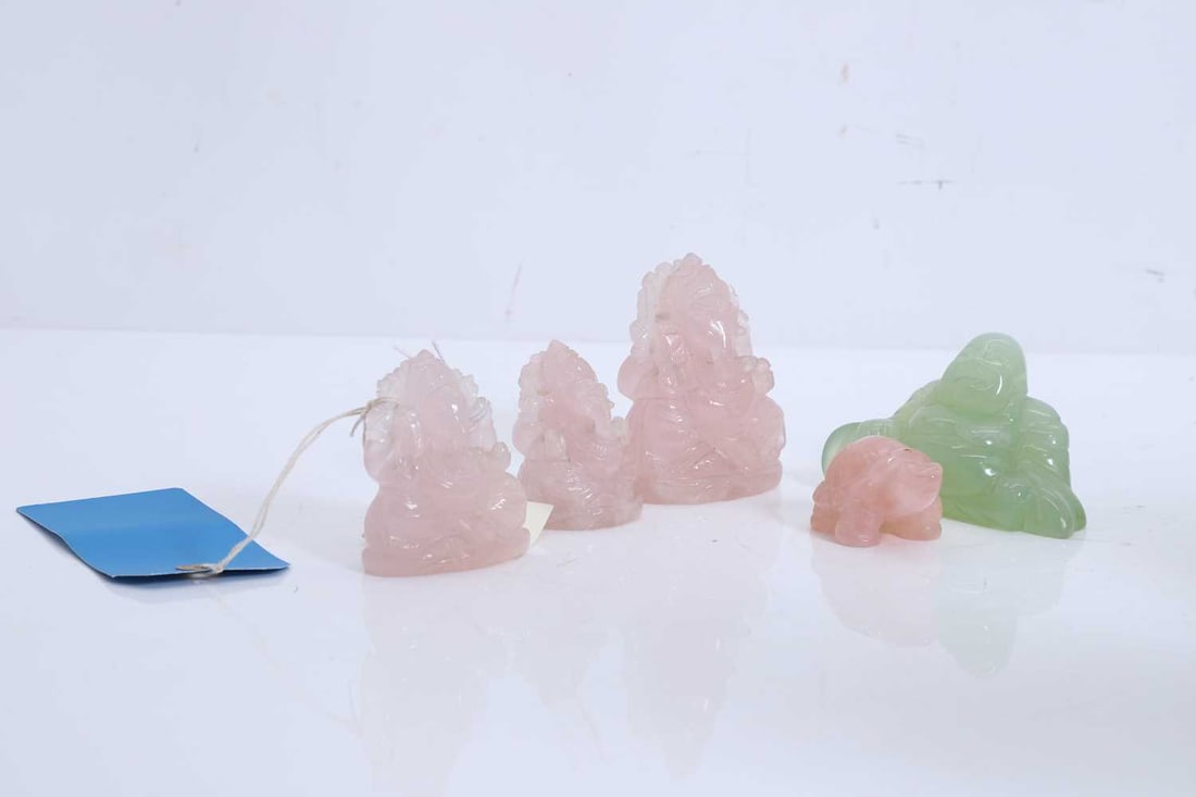 A collection of jadeite carvings,: A collection of jadeite carvings, to include three pink figures of Ganesh, a pink tortoise, and a green Buddha The largest, 11cm wide 5 Condition Report: Some minor chipsand cracking to the