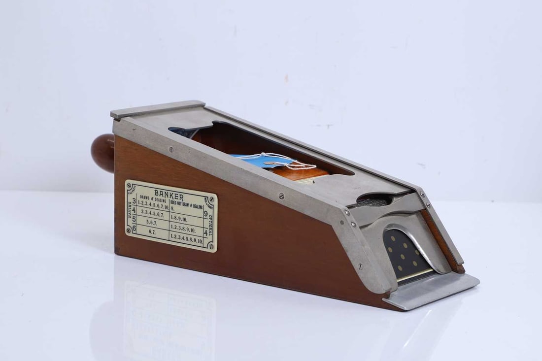 A mahogany and steel mounted casino card shoe, 20th century, French,: A mahogany and steel mounted casino card shoe, 20th century, French, of tapered rectangular form, with a sloped front fitted with a dispensing plate and guides, the interior designed to hold