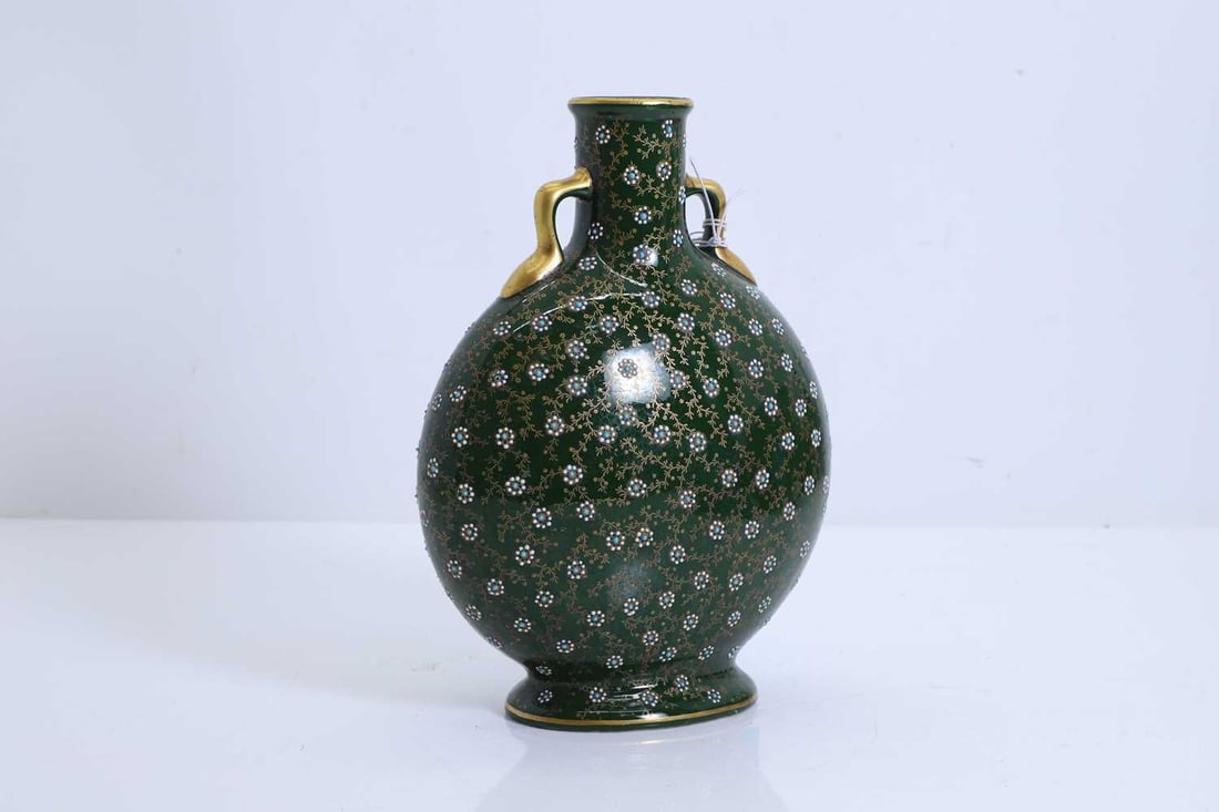 A porcelain moon flask, in the Chinese-style,: A porcelain moon flask, in the Chinese-style, of typical form, with gilded handles, the body painted with flowers amongst gilded vines, numbered '4566' to base 25cm high Condition Report: Fading