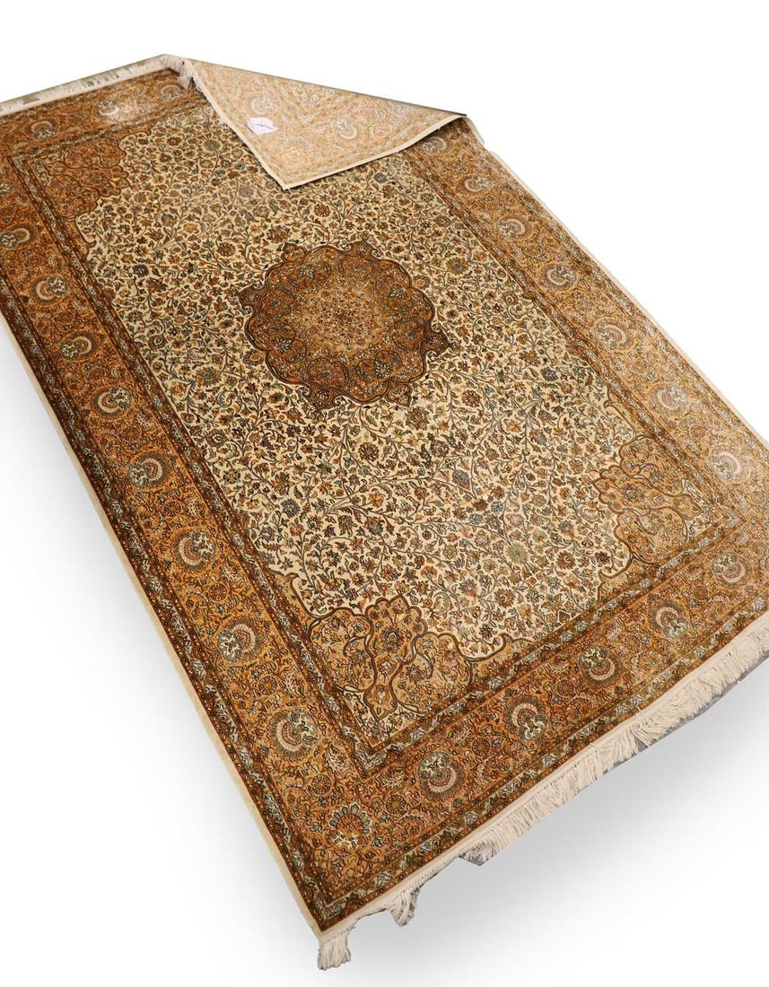 A Persian design part silk rug,: A Persian design part silk rug, the ivory field centred by an elaborate cusped medallion in shades of camel, pale blue and soft sage, issuing an intricate all-over design of scrolling foliate and