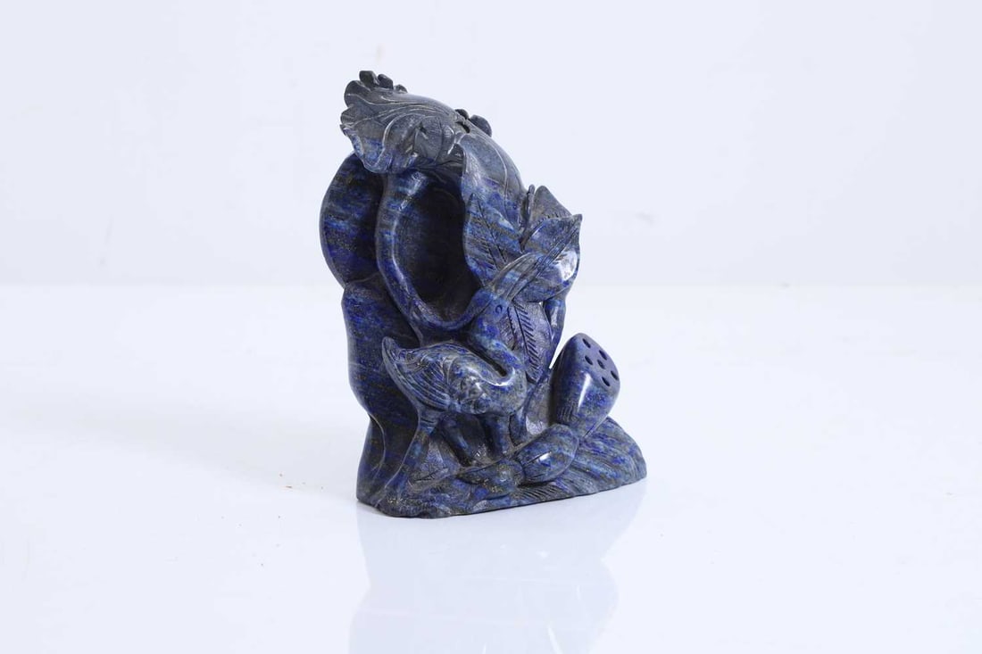 A Chinese lapis lazuli carving, 20th century,: A Chinese lapis lazuli carving, 20th century, of an egret in a lotus pond 12cm wide, 15cm high