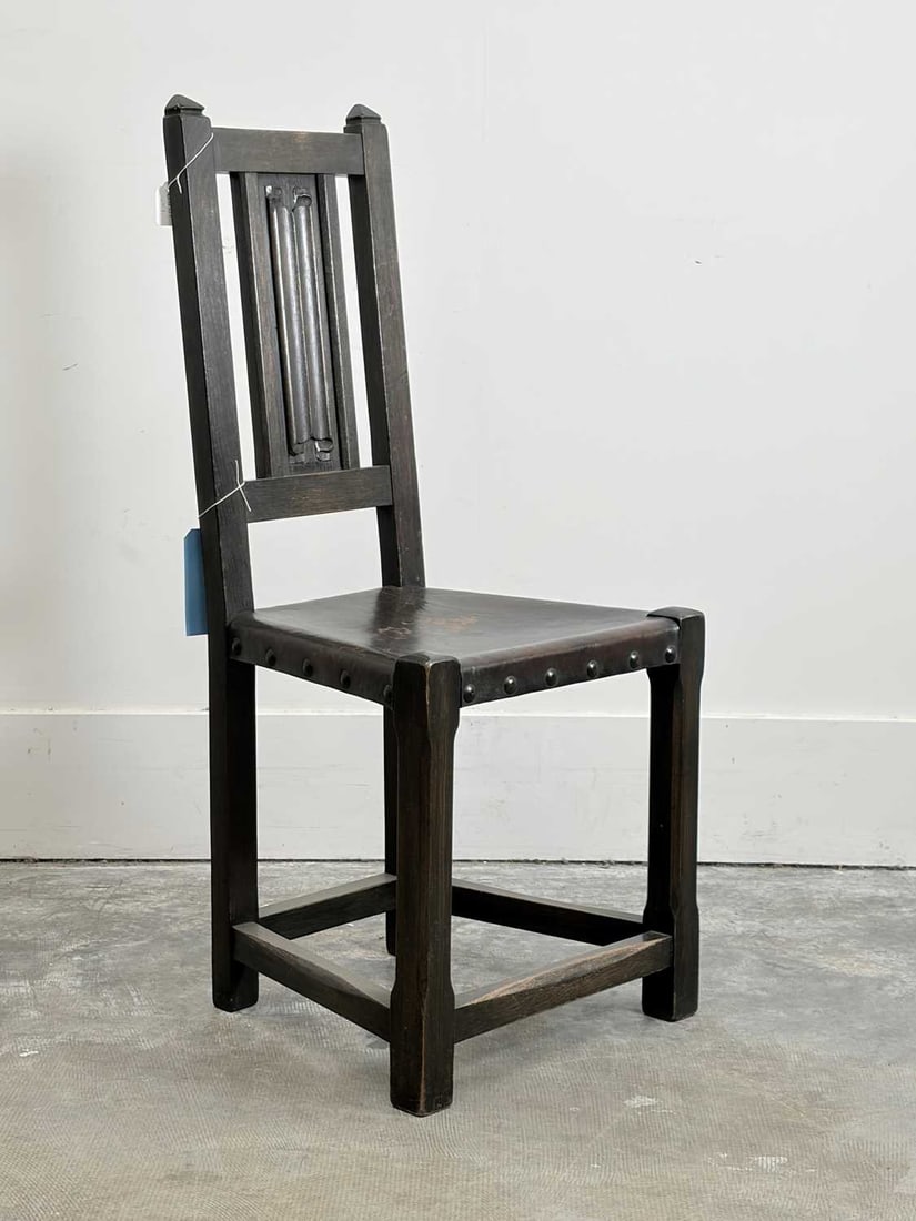 An oak hall chair, late 19th century,: An oak hall chair, late 19th century, with an arrowhead topped frame and a linen-fold back splat, the leather seat with large metal studs 44.5cm wide, 42cm deep, 103cm high