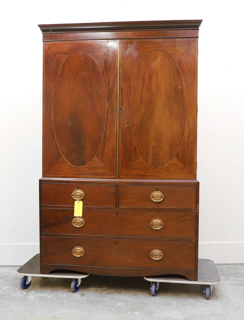 A George III mahogany inlaid linen press, late 19th century / early 20th century,: A George III mahogany inlaid linen press, late 19th century / early 20th century, converted to a wardrobe, with a hanging rail and hooks, cedar-lined inside and to the base drawer, one piece 