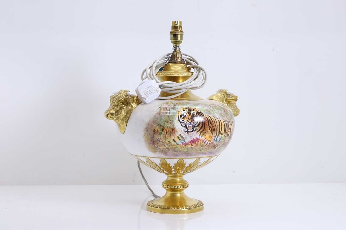 A Litherland tiger decorated table lamp, of recent manufacture,: A Litherland tiger decorated table lamp, of recent manufacture, with gilded bull masks to the sides, and the reserve painted with tigers feasting on prey, terminating in the circular gilt base 38cm
