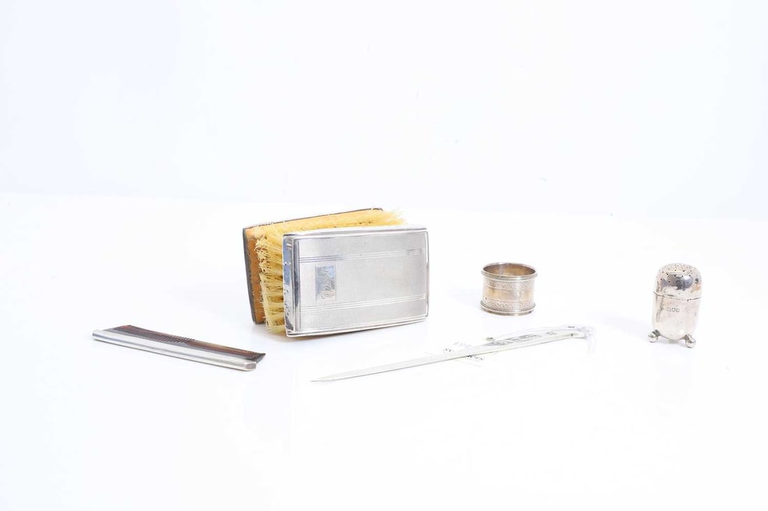 A collection of silver,: A collection of silver, to include, two silver-cased brushes and a cased comb by W I Broadway & Co, Birmingham, 1978, a letter opener by Francis Howard, Sheffield, 1978, a pepperette by napkin