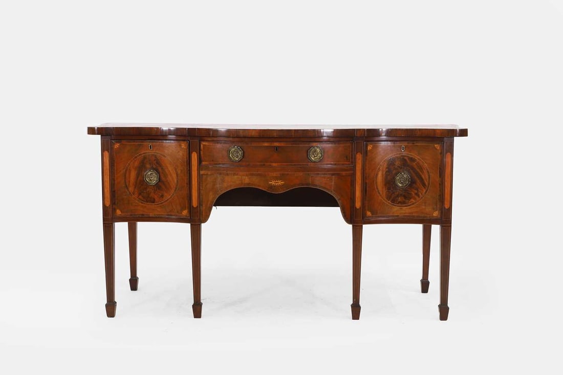 A George III mahogany sideboard, circa 1790,: A George III mahogany sideboard, circa 1790, the crossbanded serpentine top over an arrangement of drawers, raised on tapering supports 182cm wide, 68cm deep, 89cm highProvenance: Purchased at auctio