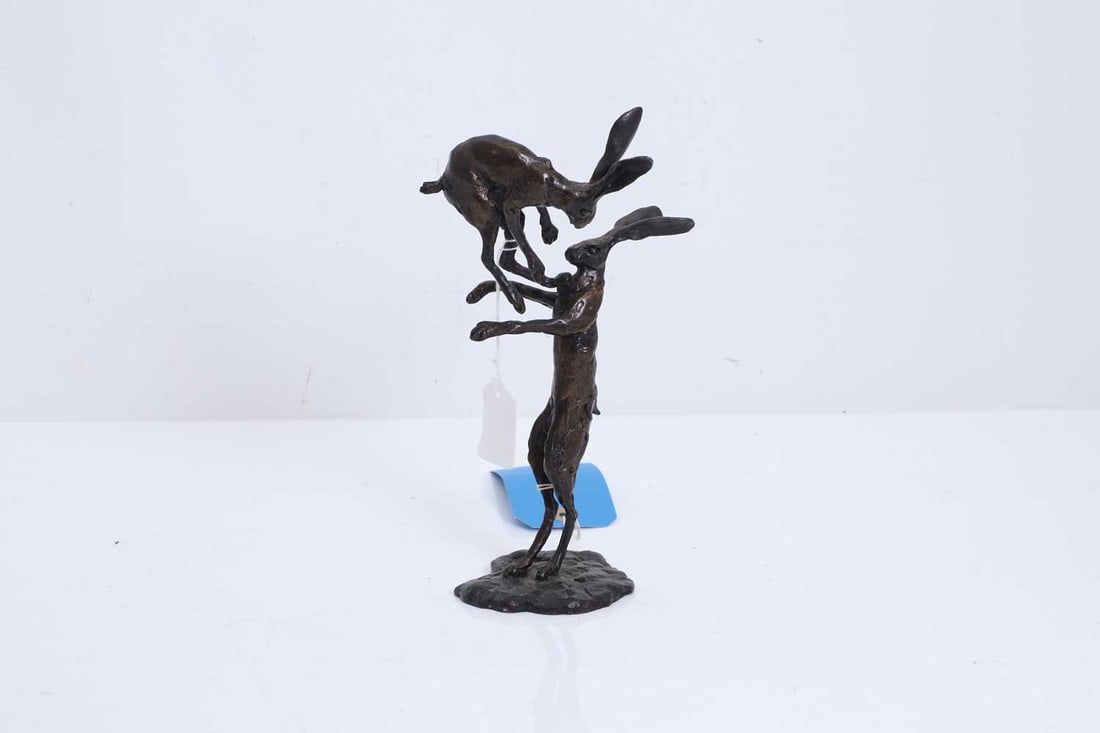 A bronze sculpture of two fighting hares, 20th century,: A bronze sculpture of two fighting hares, 20th century, depicting two stylised hares fighting, on a naturalistic base 13cm wide, 26cm high Condition Report: No signature or foundry marks. Some