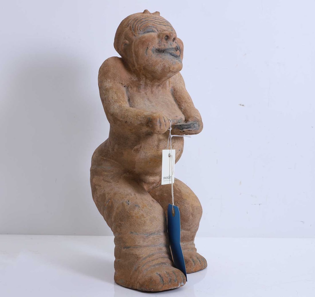 A Chinese pottery figure, in the Han-dynasty style,: A Chinese pottery figure, in the Han-dynasty style, of a musician, modelled seated, holding a drumstick in his right hand, a drum in his left 45cm high Condition Report: Some marks and scratches