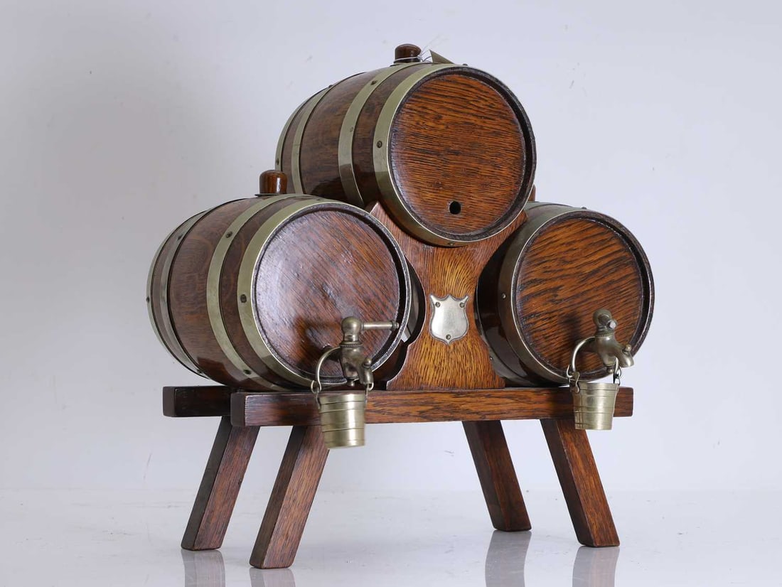 A novelty oak and brass mounted triple whisky barrel drinks dispenser, 20th century,: A novelty oak and brass mounted triple whisky barrel drinks dispenser, 20th century, on joined stand, with two novelty buckets, and blank cartouche to the stand 35.5cm wide, 39cm high Condition
