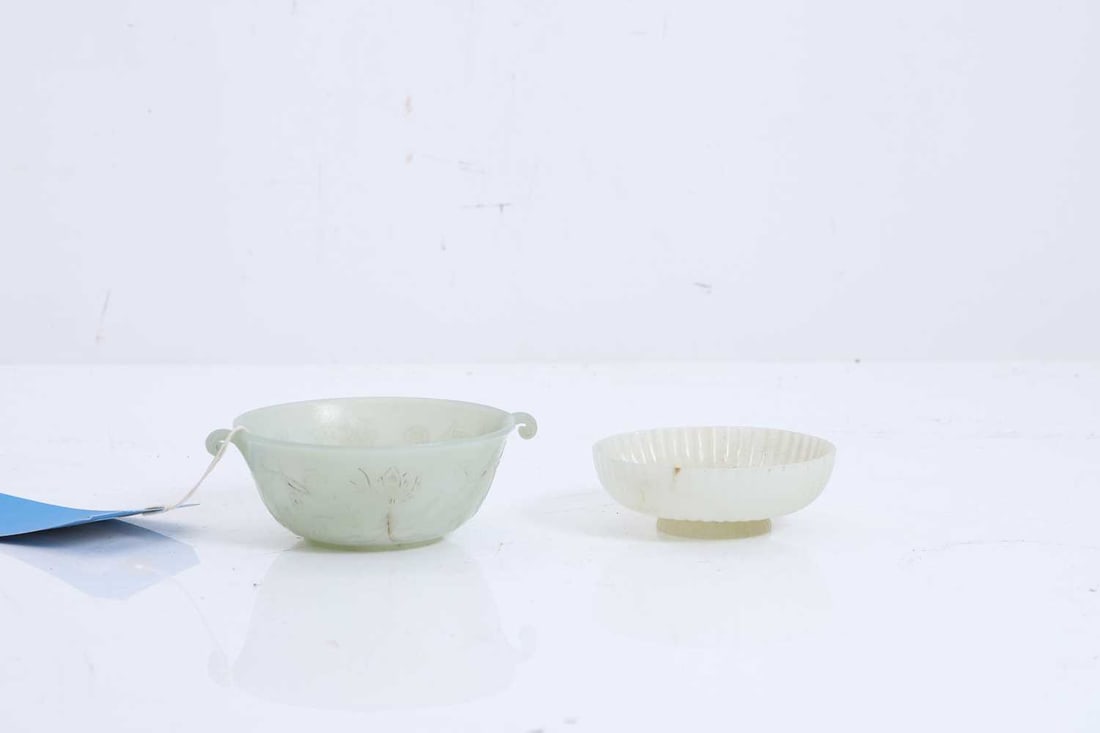 A Chinese carved jade bowl and associated cover, 20th century,: A Chinese carved jade bowl and associated cover, 20th century, the bowl carved with twin scrolling handles, the gently rounded sides decorated with stylised lotus and foliage, the associated cover