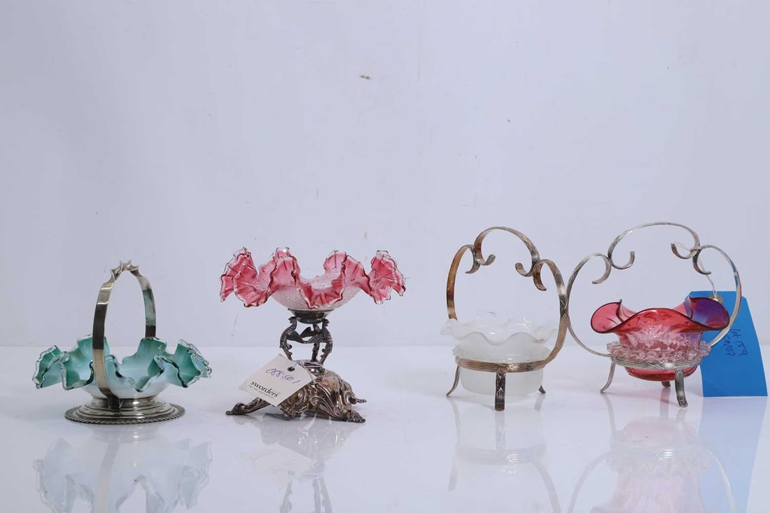 A cranberry glass sweetmeat bowl,: A cranberry glass sweetmeat bowl, with white metal frame, together with three other similar examples, one with an ombre white to green fluted bowl, another with a vaseline glass fluted bowl, and a