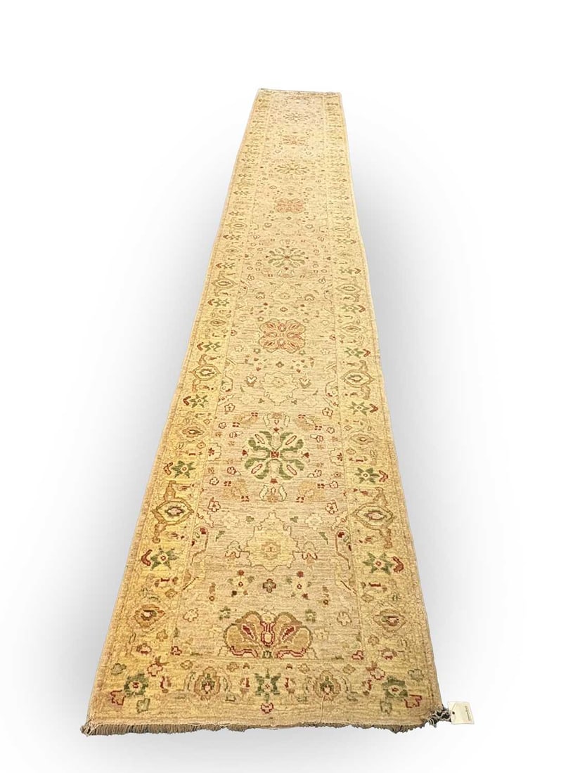 A pale wool Oushak style runner, 20th century,: A pale wool Oushak style runner, 20th century, probably Turkish, the elongated field woven with a series of stylised palmettes and rosettes in soft shades of madder red, sage green and muted ochre,