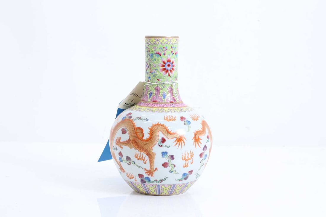 A Chinese famille rose vase, 20th century,: A Chinese famille rose vase, 20th century, painted with two dragons chasing a flaming pearl amongst clouds, the neck with chryanthemums and scrolls between ruyi banding on a green ground, with a