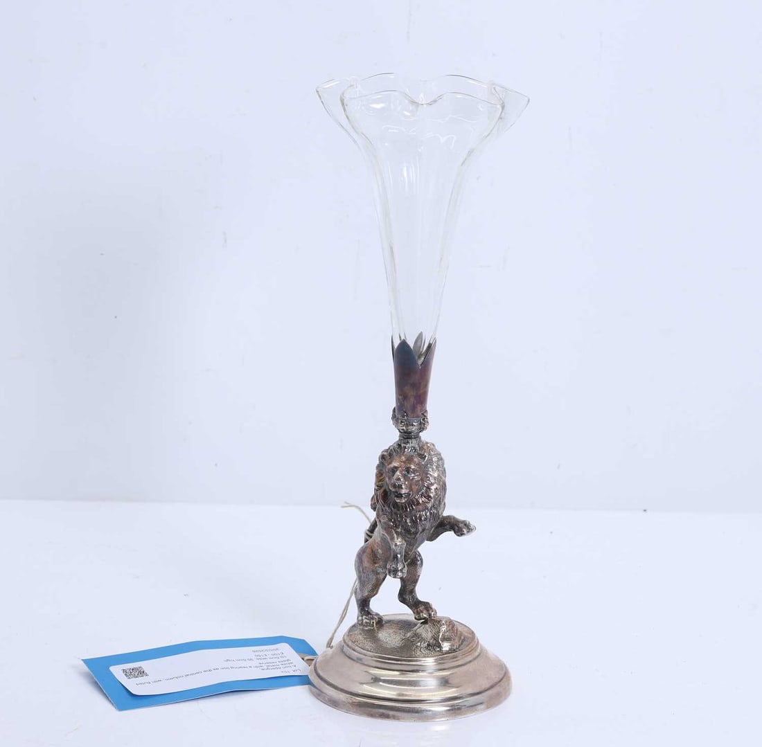 A lion epergne,: A lion epergne, white metal, with a rearing lion as the central column, with fluted glass reserve 10.5cm wide, 30.5cm high 2 Condition Report: Tarnishing throughout. Scratches to the surface. 