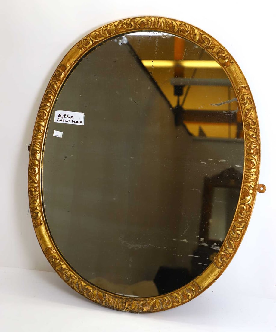 A George II style giltwood oval wall mirror, 19th century,: A George II style giltwood oval wall mirror, 19th century, the oval frame around mottled and foxed plate 70cm wide, 84cm high Condition Report: The plate foxed and some knocks to the side with