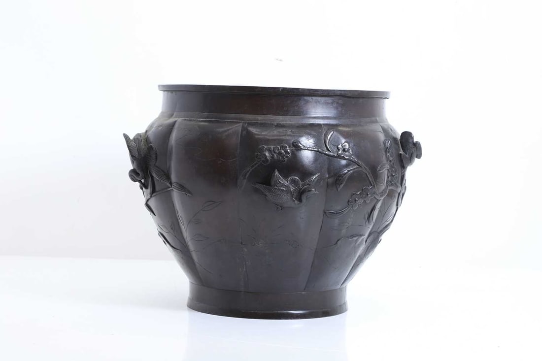 A Japanese bronze jardinière, 19th century,: A Japanese bronze jardinière, 19th century, of circular form, cast in relief with birds amongst prunus 30cm diameter