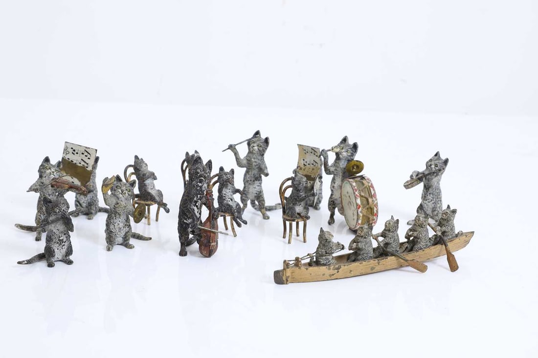 A collection of cold painted bronze cats,: A collection of cold painted bronze cats, including a cat orchestra, comprising a drummer, a conductor, a flutist, cats reading music, and cats rowing in a boat, etc. The row boat, 14.5cm long 
