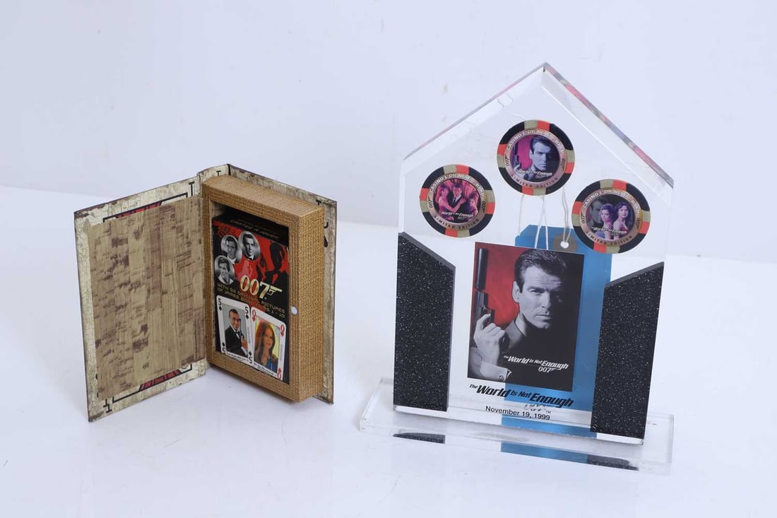 Inkworks James Bond, The World is not Enough trophy, of modern manufacture,: Inkworks James Bond, The World is not Enough trophy, of modern manufacture, poker chips set within a lucite trophy, dated 'November 19, 1999', and James Bond playing cards 18.5cm wide, 5.8cm deep,